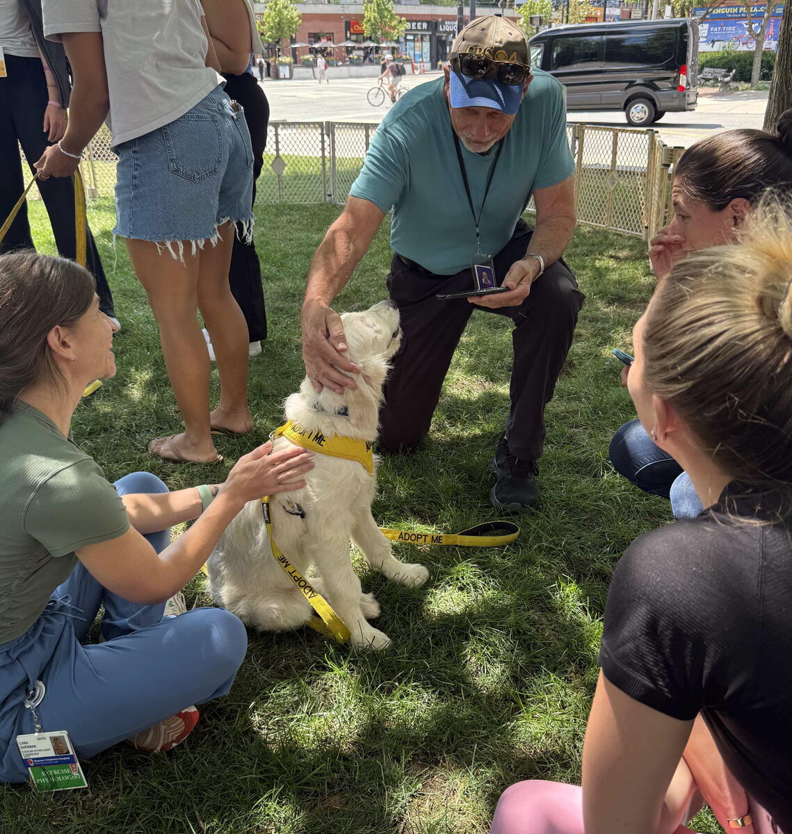 reporter kneels and pets puppies with participants