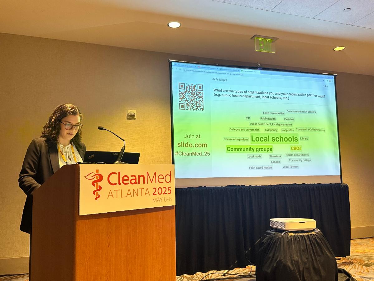 Claudia speaks at a CleanMed podium