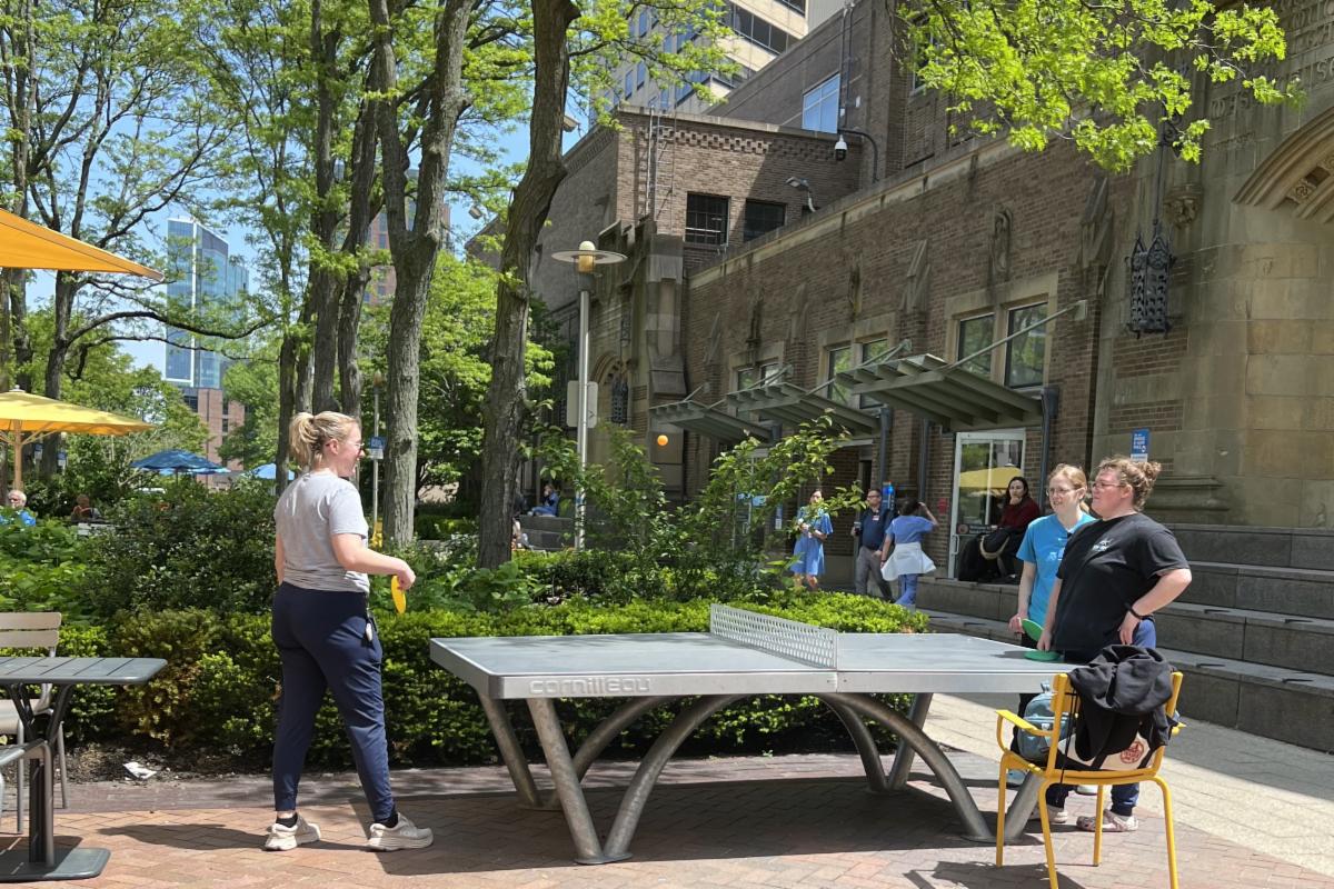 people gather around ping pong table